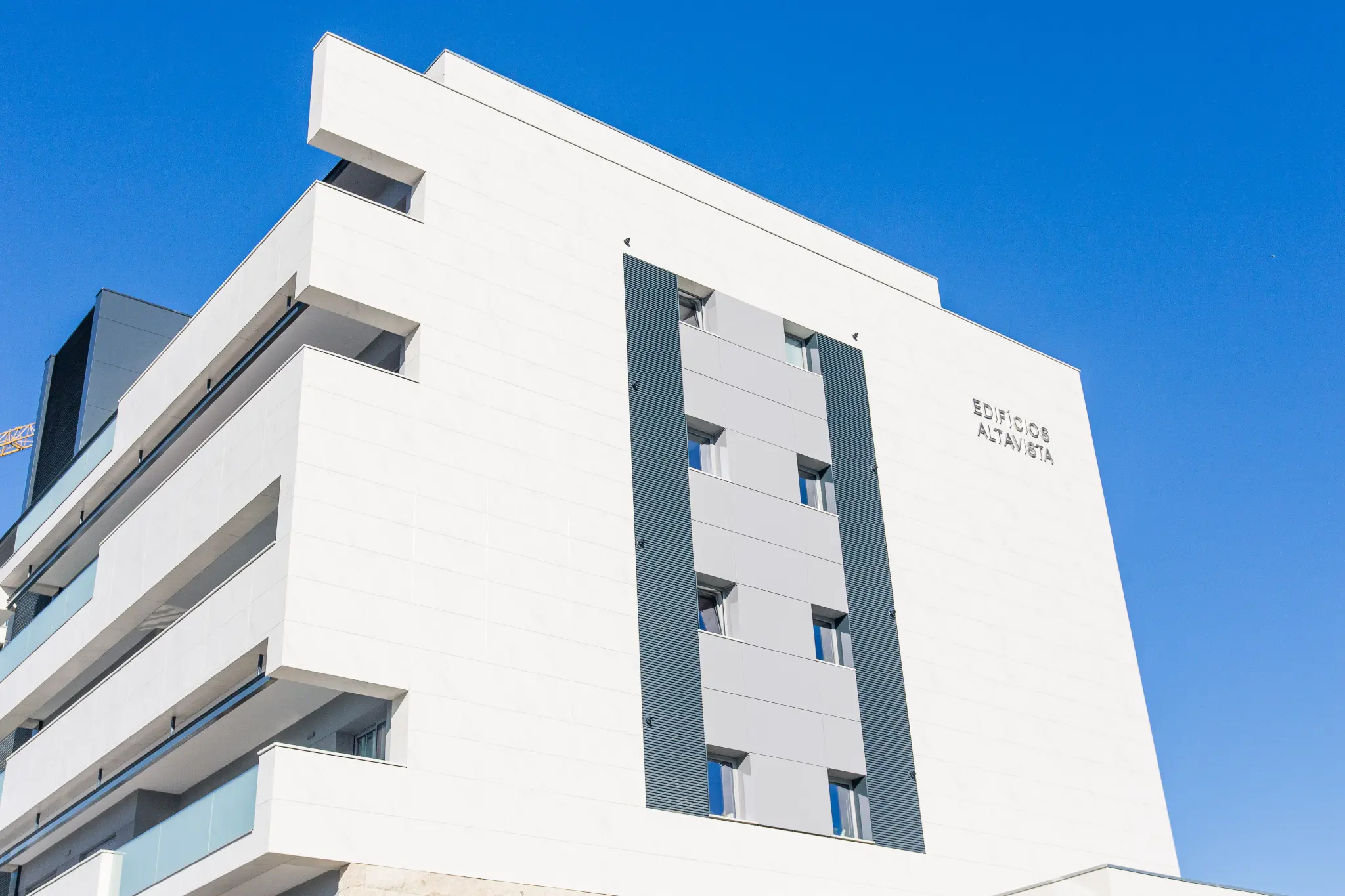 Detalhe de varandas e vegetação em edifício residencial